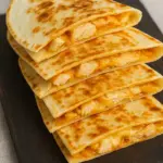 Homemade Taco Bell chicken quesadilla recipe with melted cheese and grilled tortillas served on a wooden board