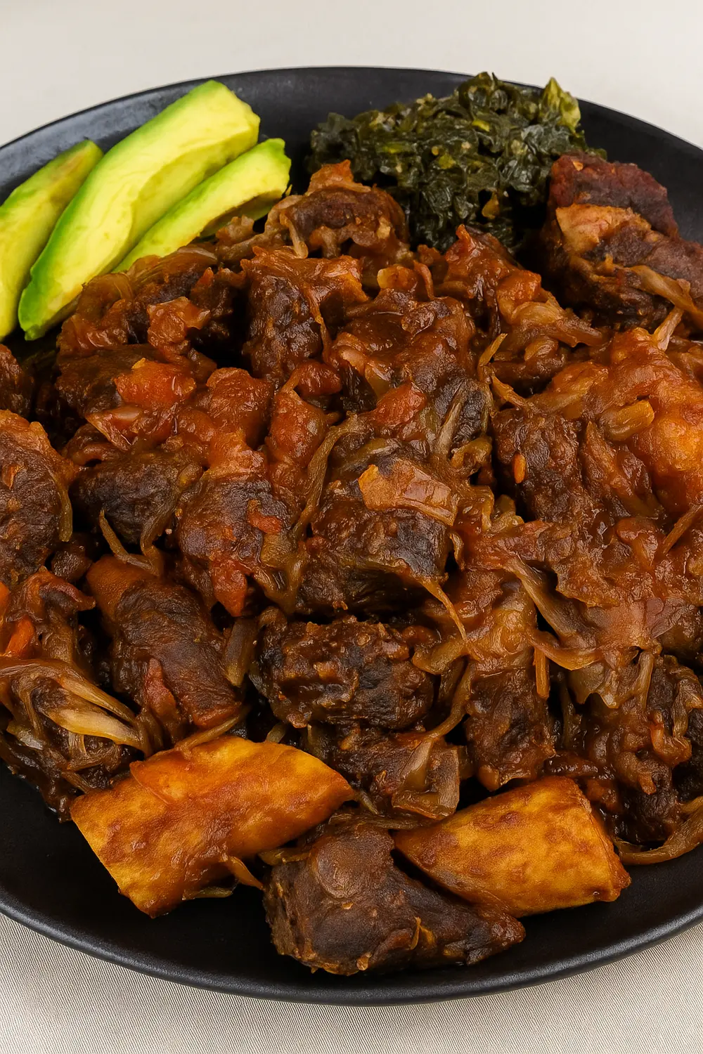 Ugandan-style pork stir fry, also known as Kikalayi pork, served with matooke, avocado slices, and cabbage on a black tray, perfect for those following a Calorie Deficit Diet.
