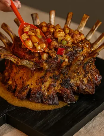 Best Crown Roast of Pork Recipe for Christmas A beautifully decorated crown roast of pork with a rich brown glaze, surrounded by roasted vegetables, perfect for Christmas dinner ideas and Thanksgiving dinner.