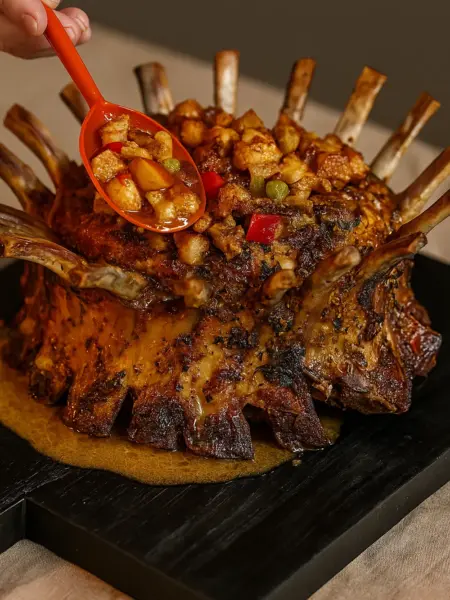 Best Crown Roast of Pork Recipe for Christmas A beautifully decorated crown roast of pork with a rich brown glaze, surrounded by roasted vegetables, perfect for Christmas dinner ideas and Thanksgiving dinner.