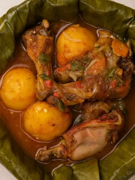 Best Chicken Stew Recipe (Luwombo Chicken) Traditional Ugandan luwombo chicken stew recipe featuring smoked chicken simmered with potatoes, vegetables, and rich sauce served in a banana leaf.