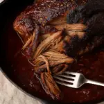 Extremely tender, melt-in your mouth smoked beef brisket drenched in a thick, savory BBQ sauce, perfect for family dinners or Christmas holiday feasts.