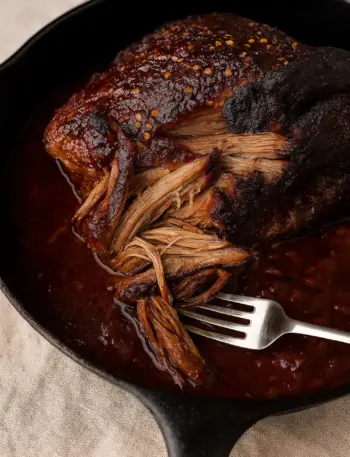 Extremely tender, melt-in your mouth smoked beef brisket drenched in a thick, savory BBQ sauce, perfect for family dinners or Christmas holiday feasts.